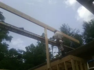 Carpenter setting a ridge beam over a new addition frame — Ice Dam Removal by Roofing Brothers in Morgantown