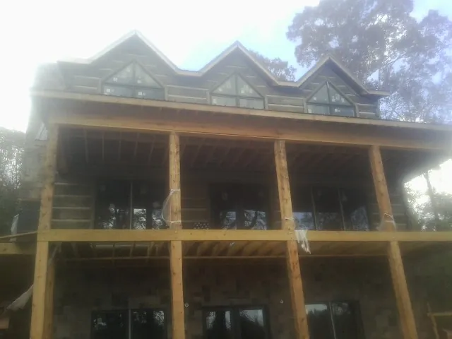 Dormers and porch framing on a large log home under construction — Roof Coating work by our crew in Morgantown